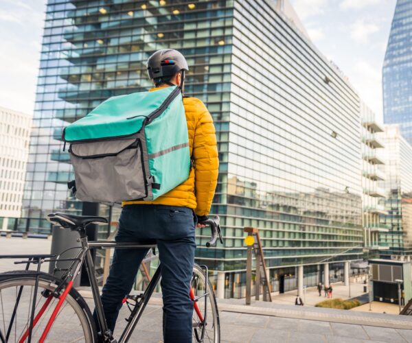 delivery-person-standing-with-bike-in-city-2026-03-24-07-16-26-utc (1) (1) (1)