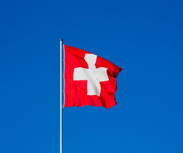 Swiss flag against blue sky