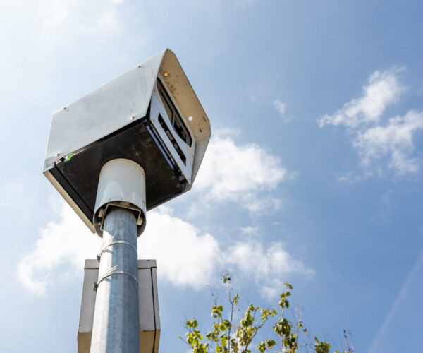 Close-up on speed trap surveillance camera along highway.